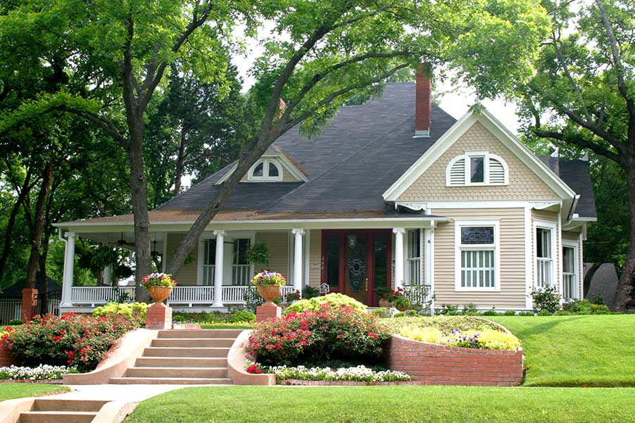 A well painted home with a beautiful lawn and steps leading right to a front door.